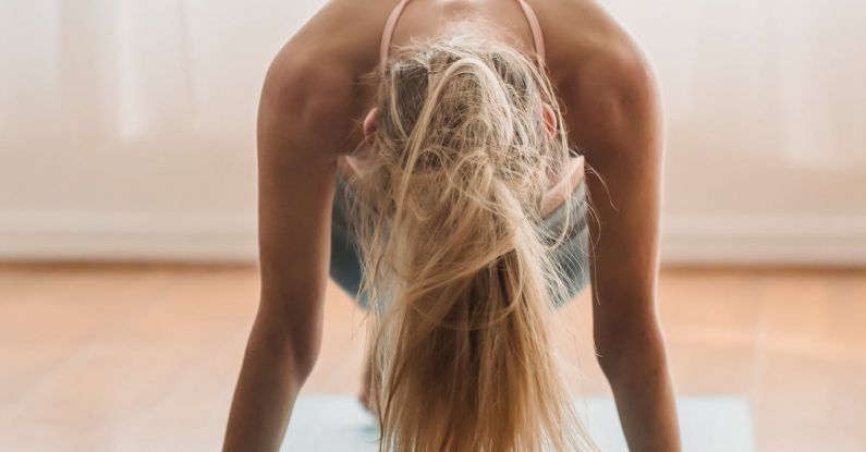 Online Tutorials - Faceless slim female standing in plank position on mat near laptop during online yoga lesson at home in living room