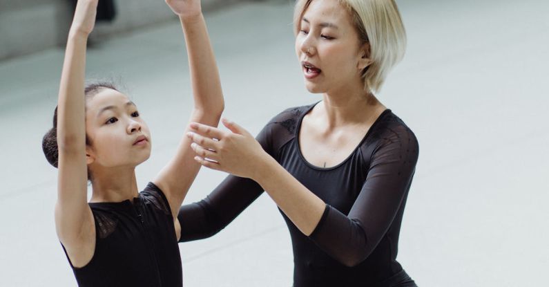 Beginners - Asian ballet instructor and girl practicing movements on floor