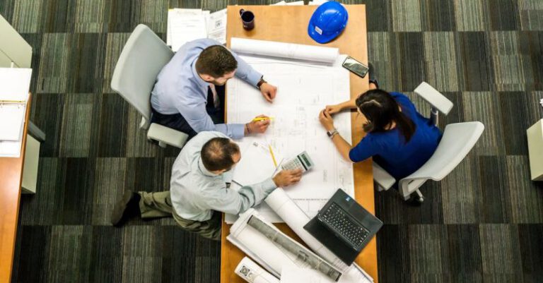 Project - Three People Sitting Beside Table